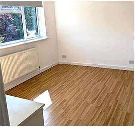 Empty bedroom with a clean wooden floor and radiator