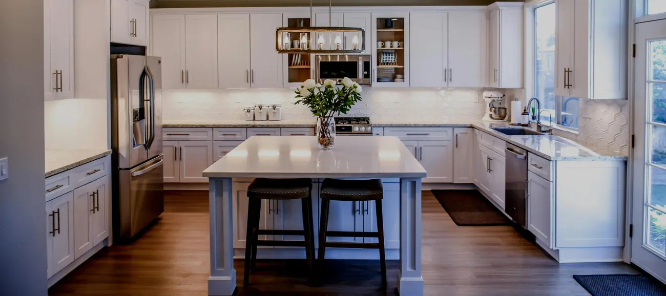 Spotless white kitchen with an island and wooden floor
