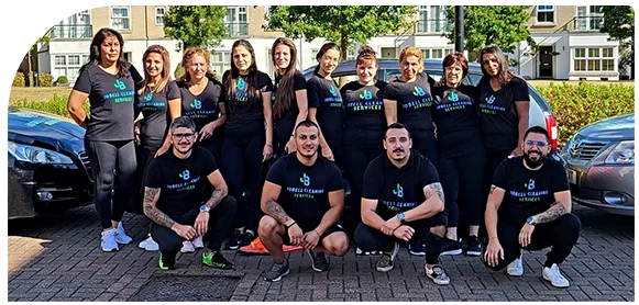 The JoBell Cleaning Services team in black uniforms posing outside